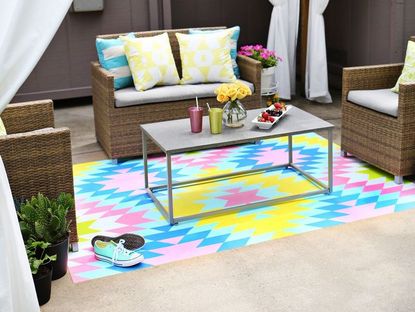 a colourful outdoor rug painted onto concrete in an aztec pattern 