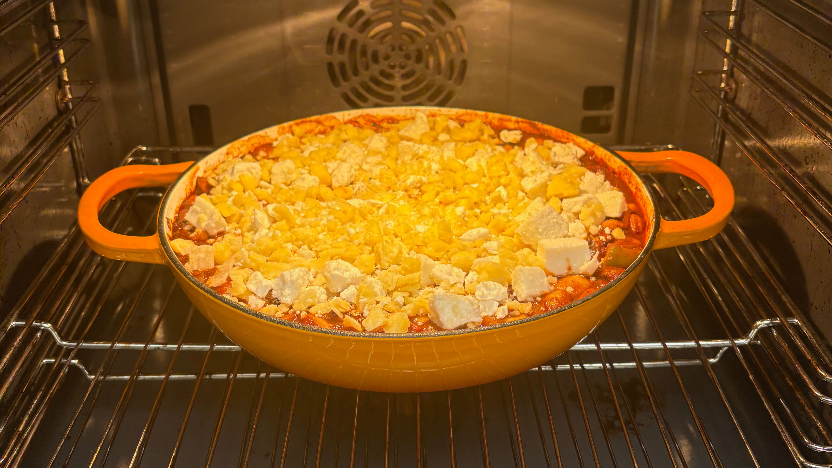 Orange cast iron pan in an oven 