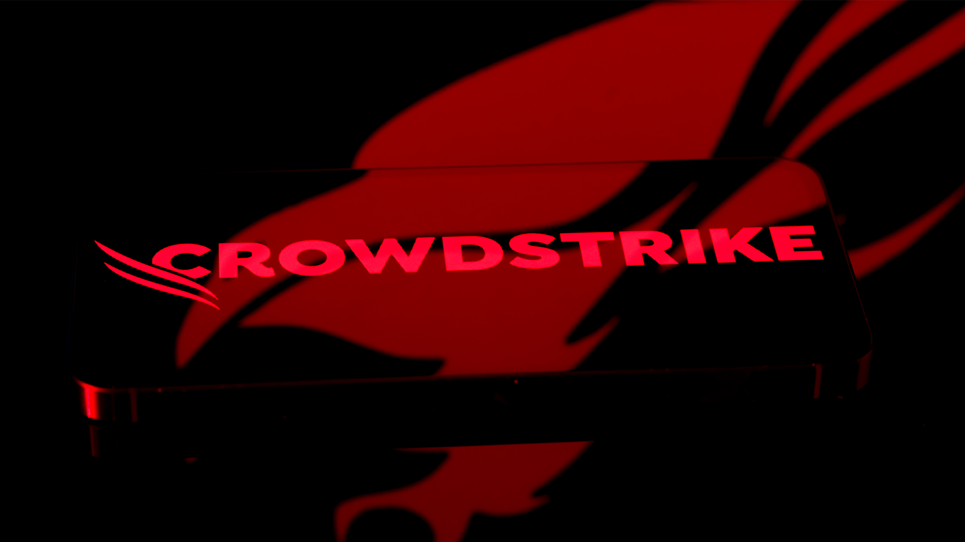 Close-up shot of the CrowdStrike logo and branding pictured on a smartphone screen, with company icon in background.