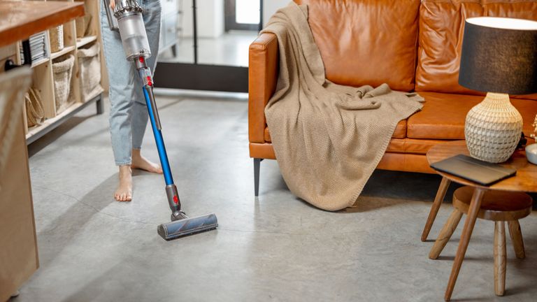 person using a cordless vacuum in the living room