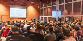 Speaker giving a talk in conference hall at education event.