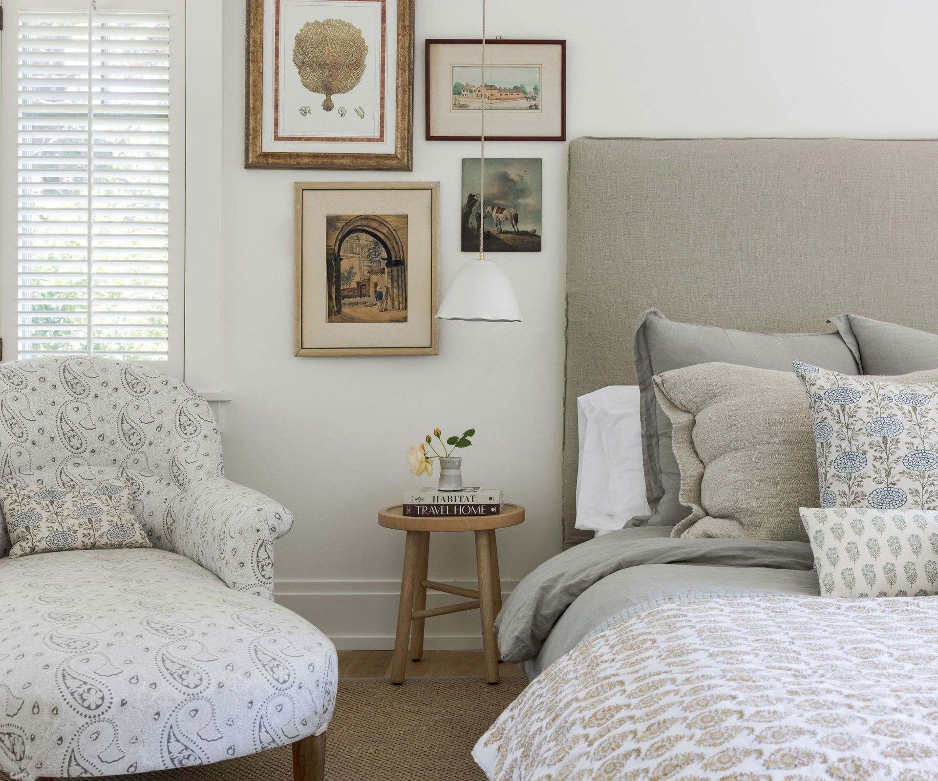 bedhead and armchair chaise and rustic stool with soft pastel colors and wooden floors