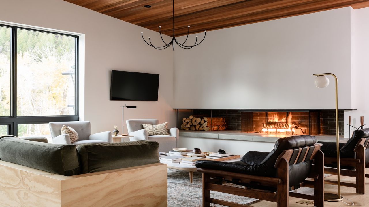 A modern white living room with large relaxed furniture around a sleek contemporary fireplace.