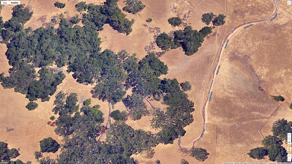 A Google satellite map showing how the Garmin Venu X1's all-systems GNSS line (blue) compares to the Garmin Forerunner 970's dual-frequency GPS line (red) for accuracy during a hike with plenty of tree cover.