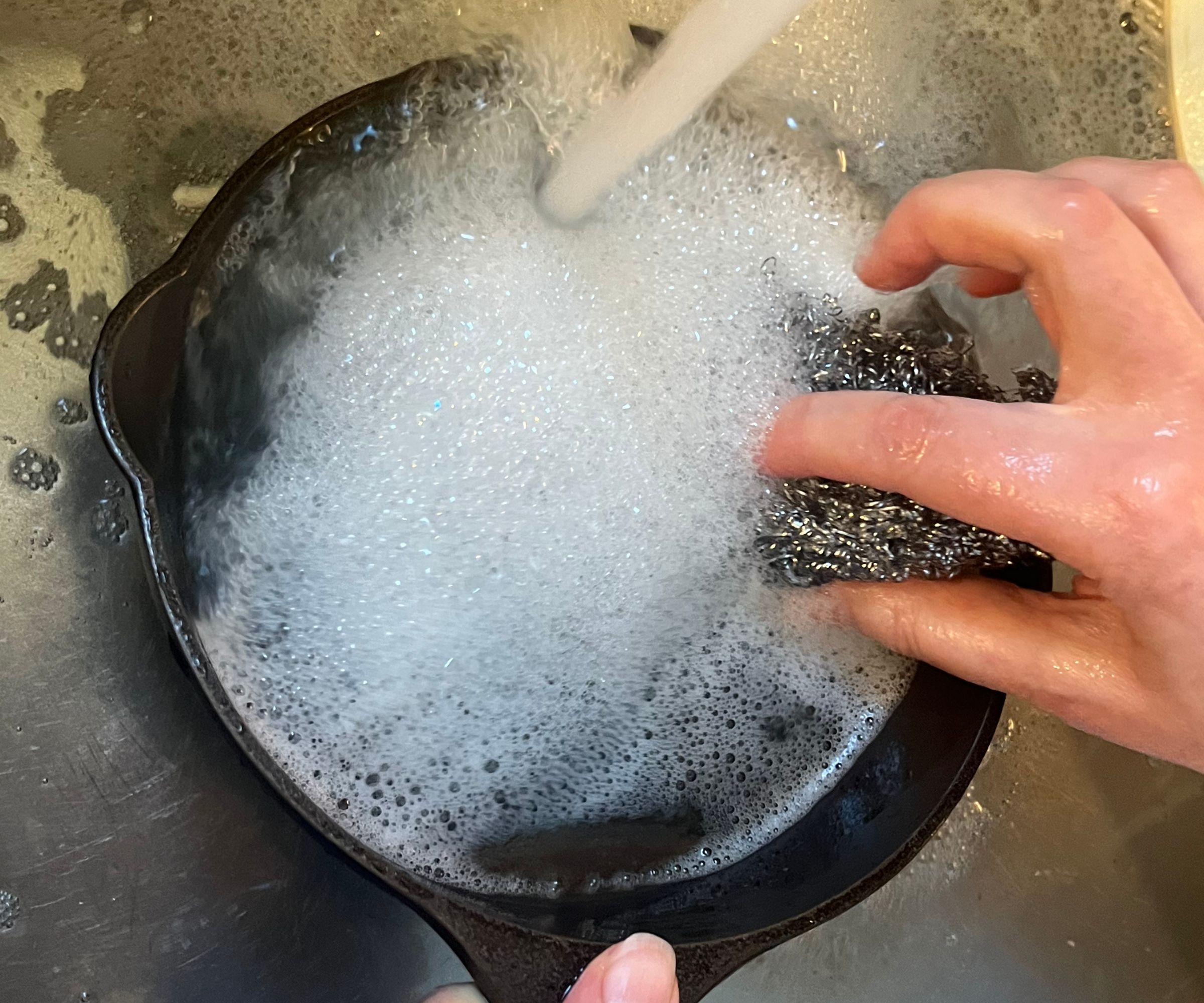 Cleaning the Lancaster Cast Iron Skillet in hot soapy water