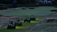 Greenkeepers on mowers before sunrise at Royal Liverpool Golf Club