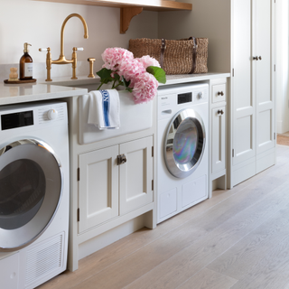 Washer and dryer in the kitchen. Pink hydrangers in a shell