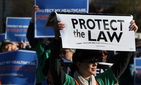 People march in favor of President Obama&amp;#039;s health care act on the first day of the Supreme Court hearings.