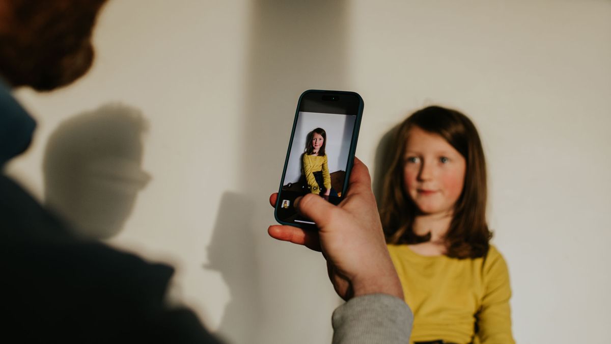 Man taking a photo of a girl using a phone