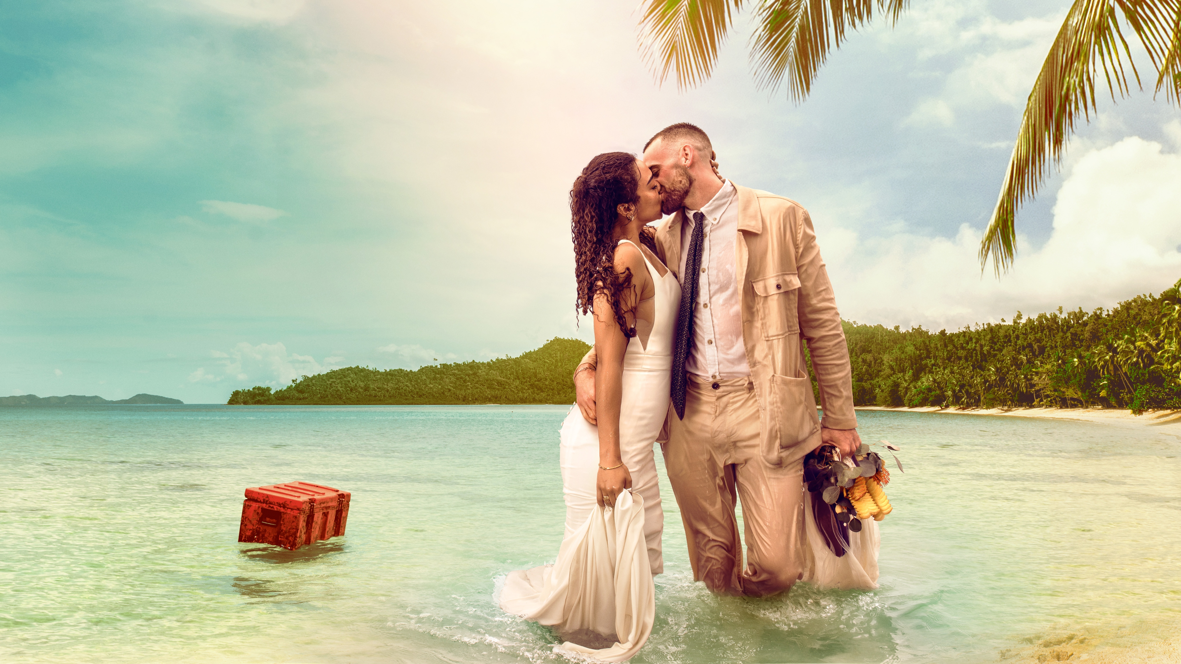 Stranded on Honeymoon Island couple Hannah and Sam wearing wedding attire and kissing in the ocean.