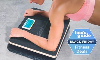 Woman resting forearms on Plankpad with phone on top and Black Friday deal badge bottom right