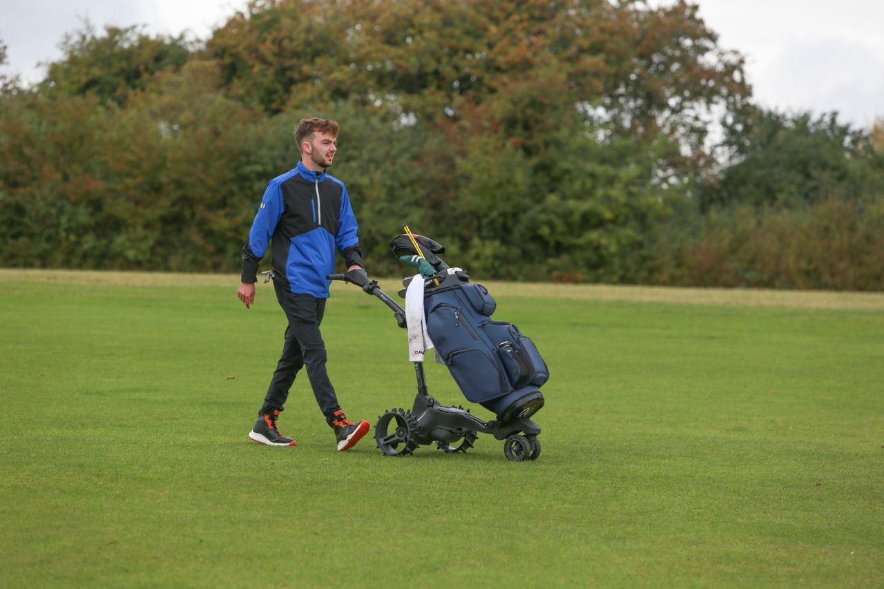 Dan Parker walking with a trolley using the Ping SensorDry S2 Pro Half-Zip Jacket