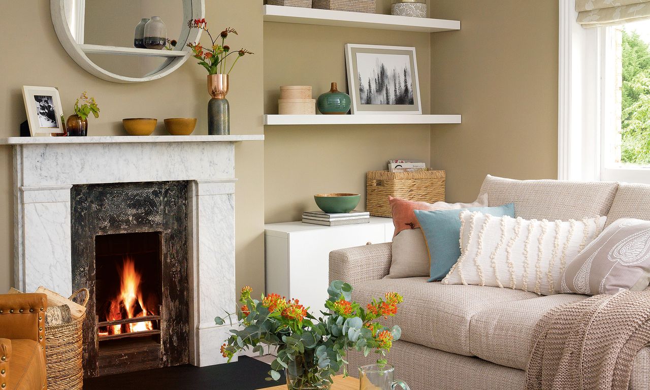 Neutral living room with fireplace, mirror, sofa and cushions