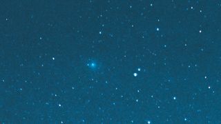 a blue-green comet in the night sky