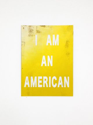 A yellow portrait poster with the words I AM AN AMERICAN written in white.