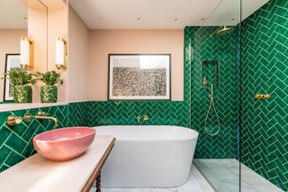 Space-boosting trick using diagonal green tiles and pink walls in a small bathrooms