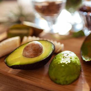 Avocado cut open on chopping board