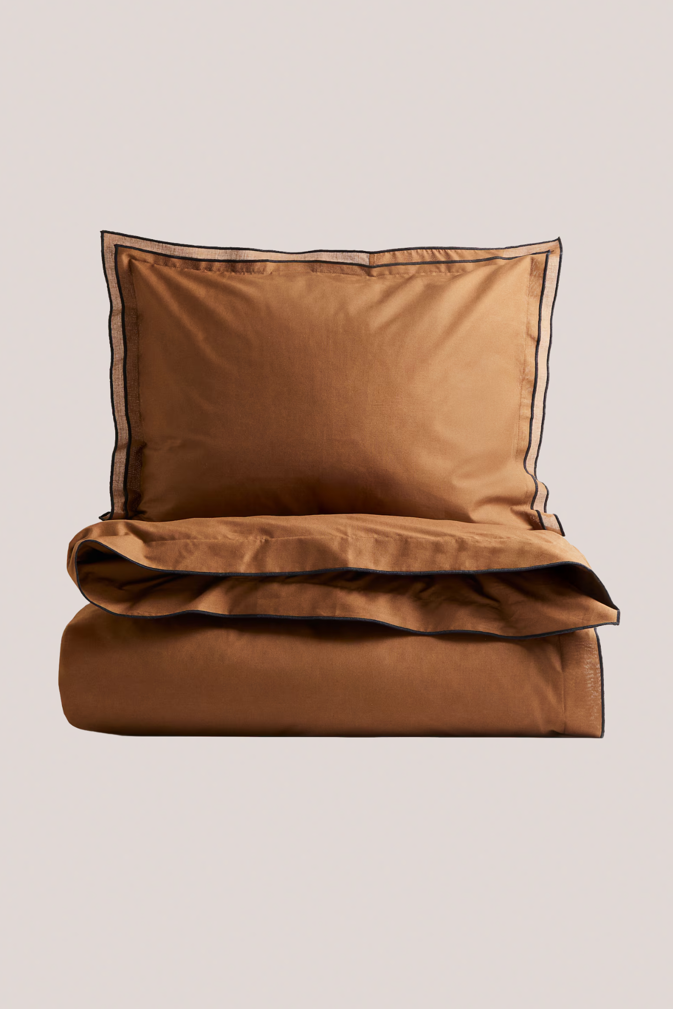 An orange bedding set with black piping