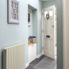 Hallway with open front door and radiator to the side