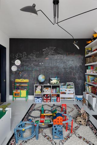 playroom with chalkboard and open shelving full of toys