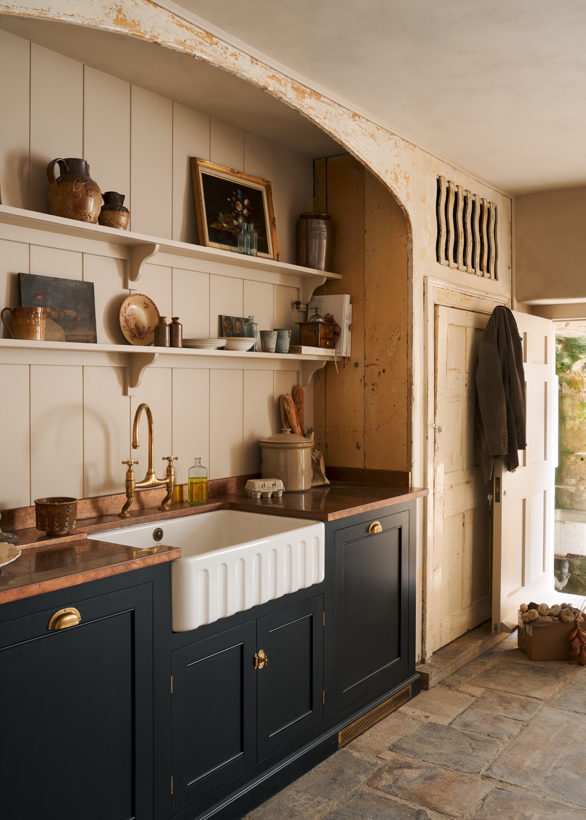 dark blue kitchen cabinets with fluted farmhouse sink by deVOL