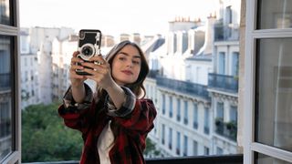 Emily in Paris season 3 - Emily holding an iPhone taking a selfie
