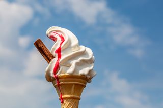 Ice cream cone with flake and strawberry sauce