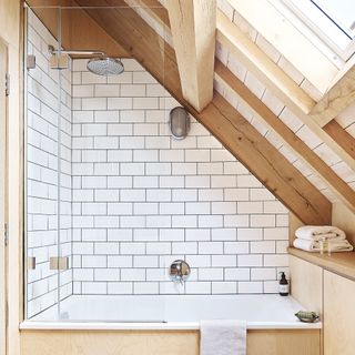 White bathroom with over the shower bath and slanted roof