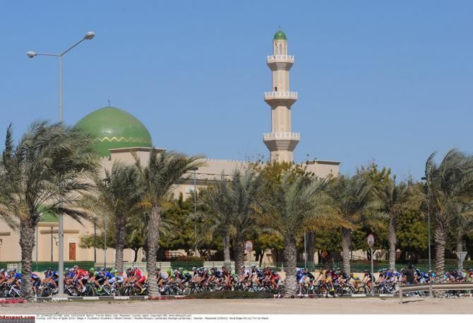 The multicoloured peloton contrasts against colours of the desert