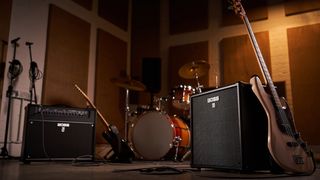 Two Boss amps in front of a drum kit in a rehearsal room