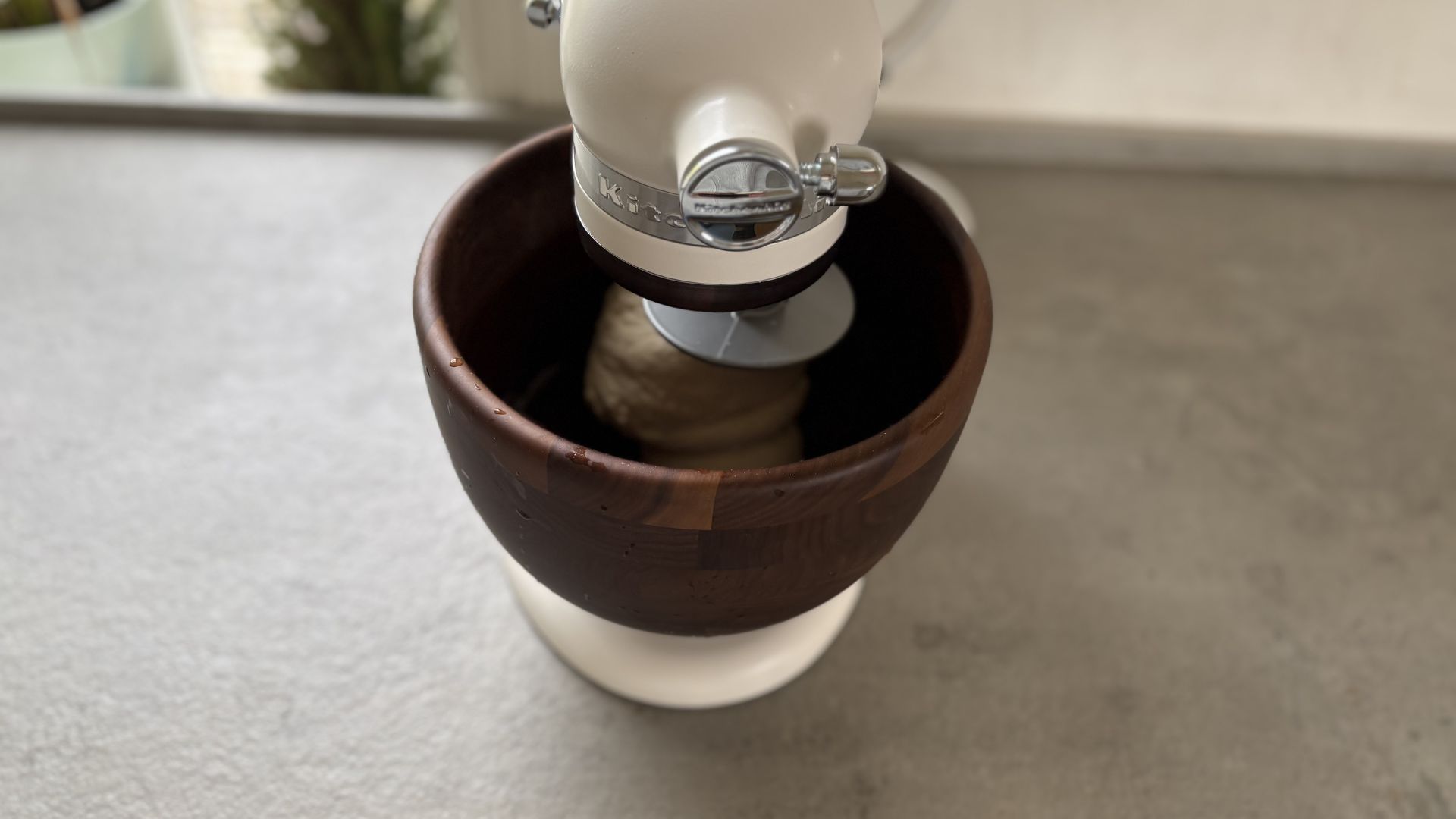 KitchenAid Artisan Stand Mixer with Wooden Bowl on the counter making doughh