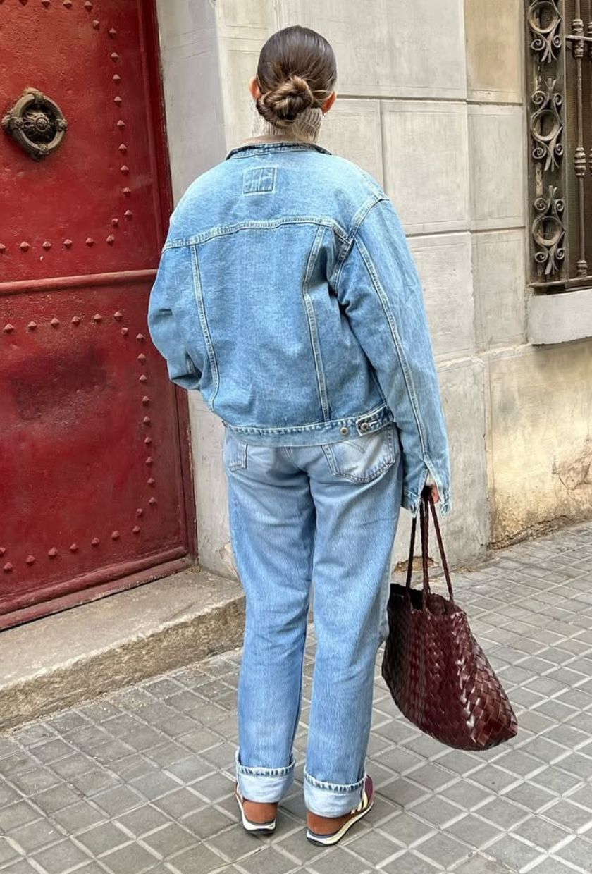 @kristencueto wears a denim bomber, turn-up jeans, trainers and leather woven tote