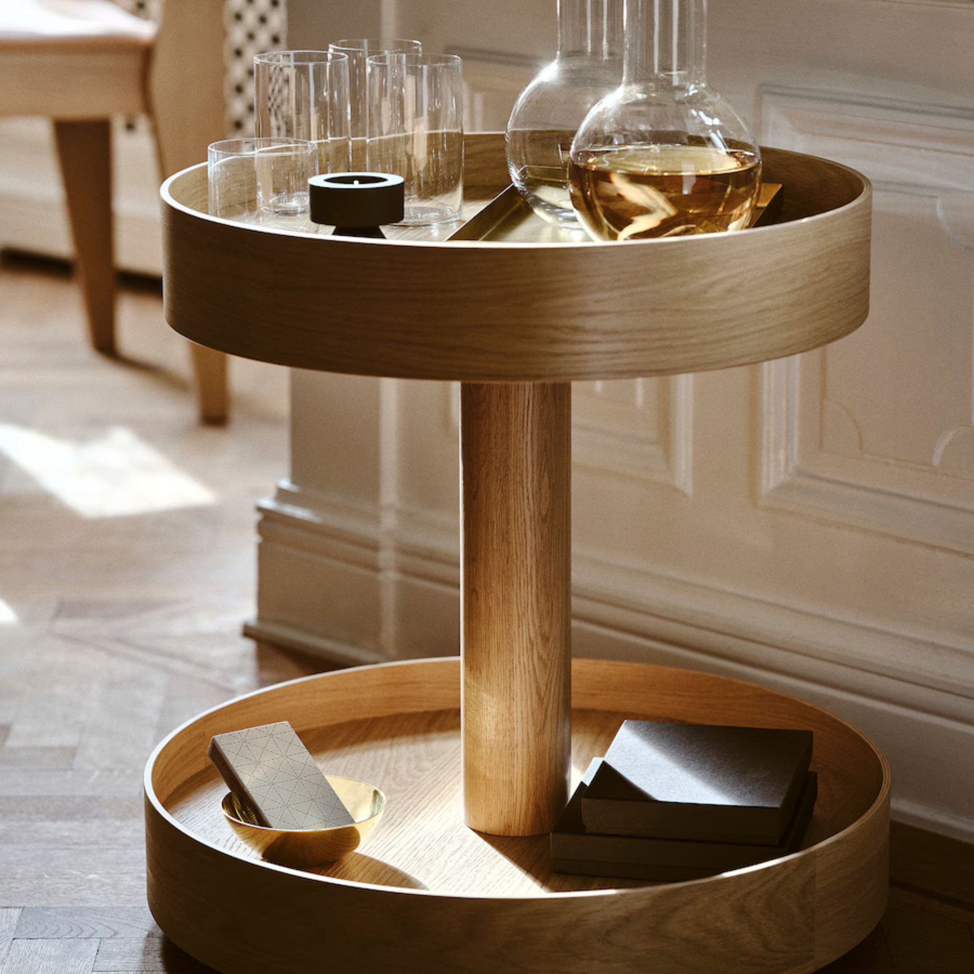 IKEA STOCKHOLM side table on castors with a decanter and glasses on top.