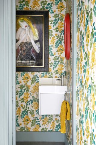 A bathroom with a yellow wallpaper in large prints