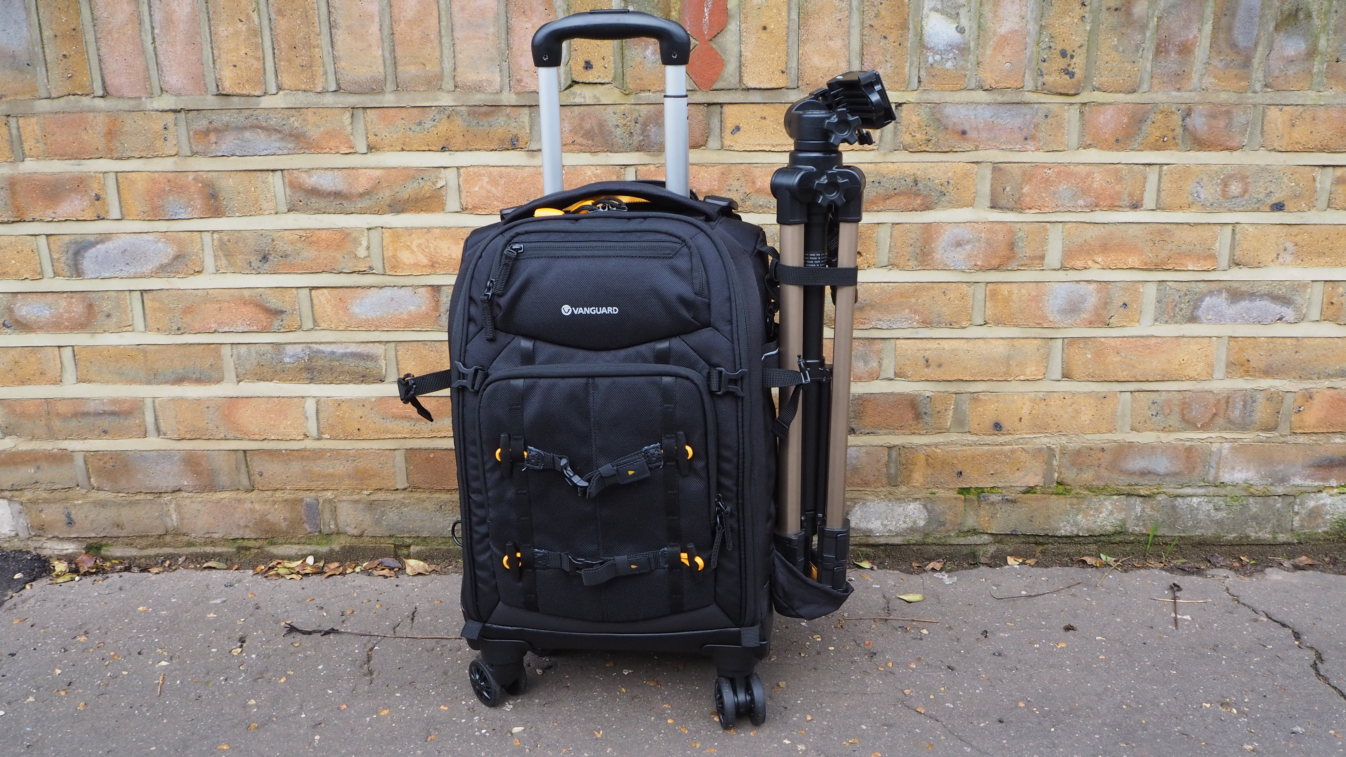 Vanguard Alta Fly 55T G2 on a street with a brick wall behind