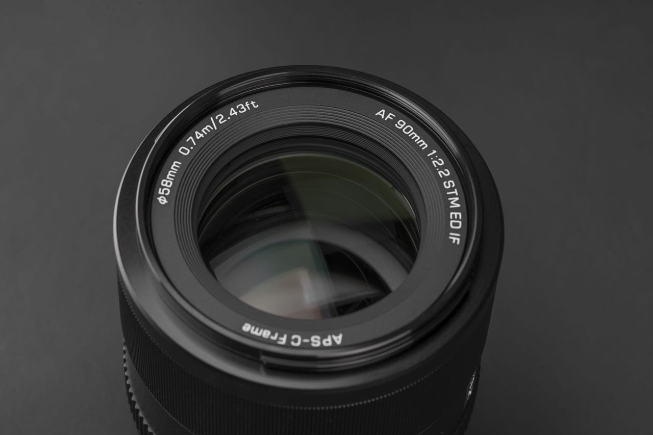 Close up of the Viltrox AF 90mm F2.2 EVO lens on a black background