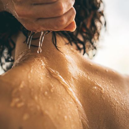 A woman showering off a body scrub