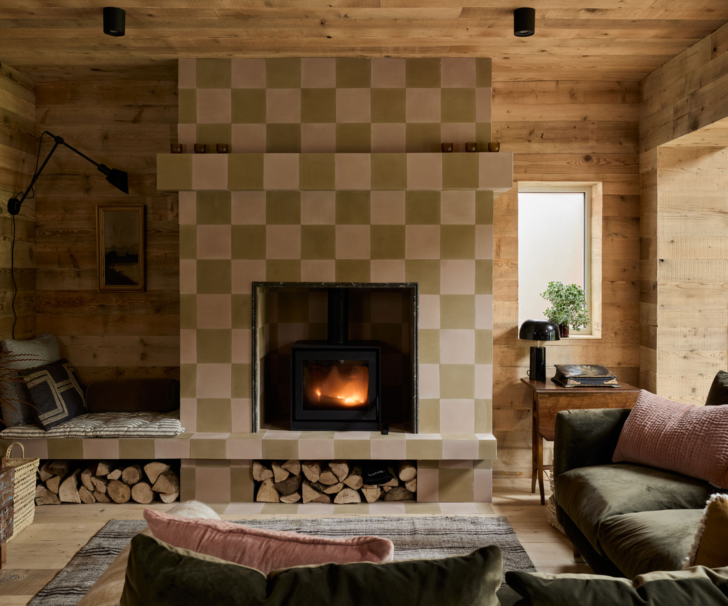 cosy living room with wooden wall cladding and wood burning stove with tiled surround