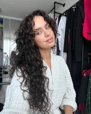 A woman with long curly dark hair.