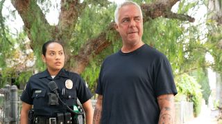 Officer Reina and Harry Bosch standing outside in front of a big tree in Bosch: Legacy