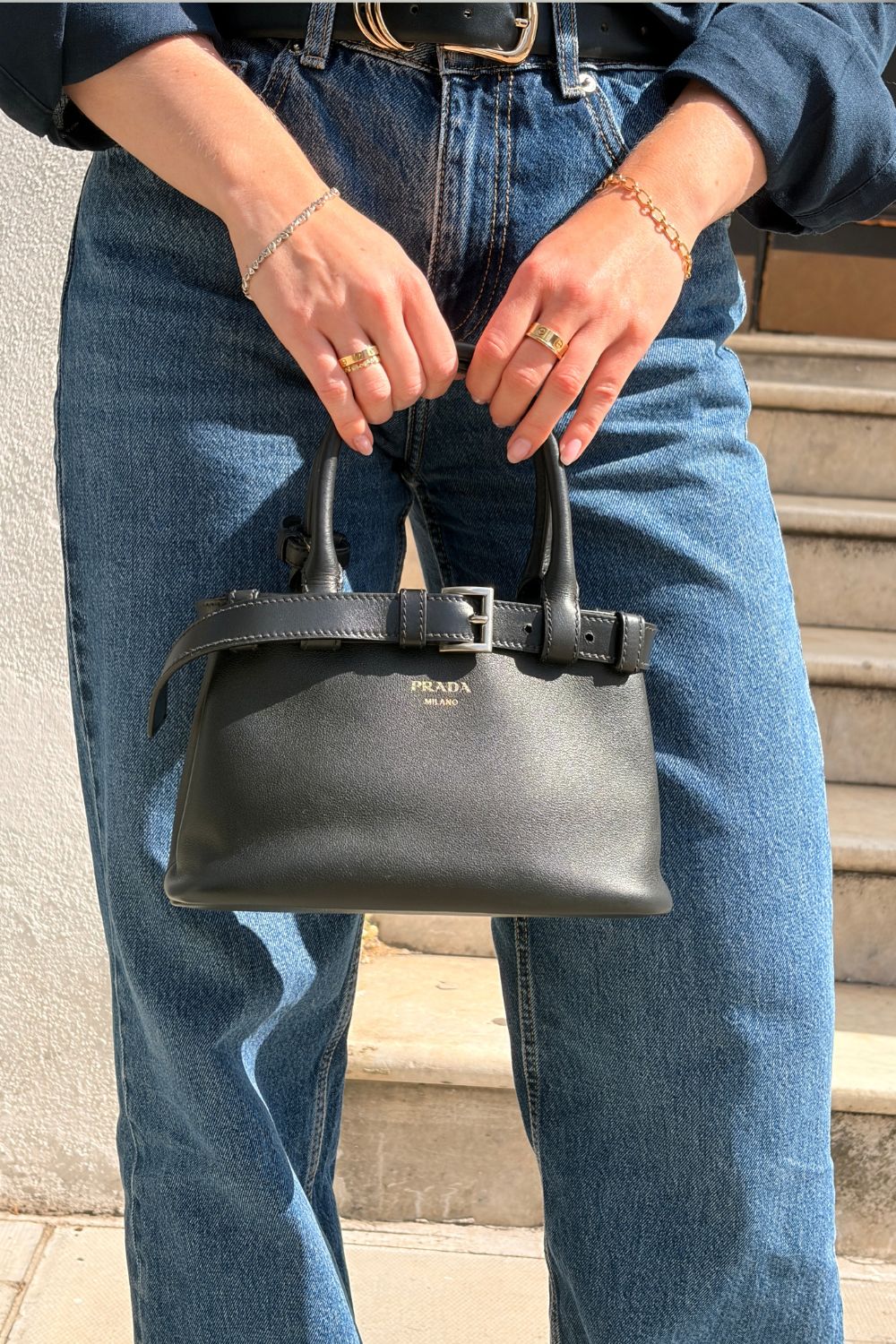 Woman carries prada buckle bag