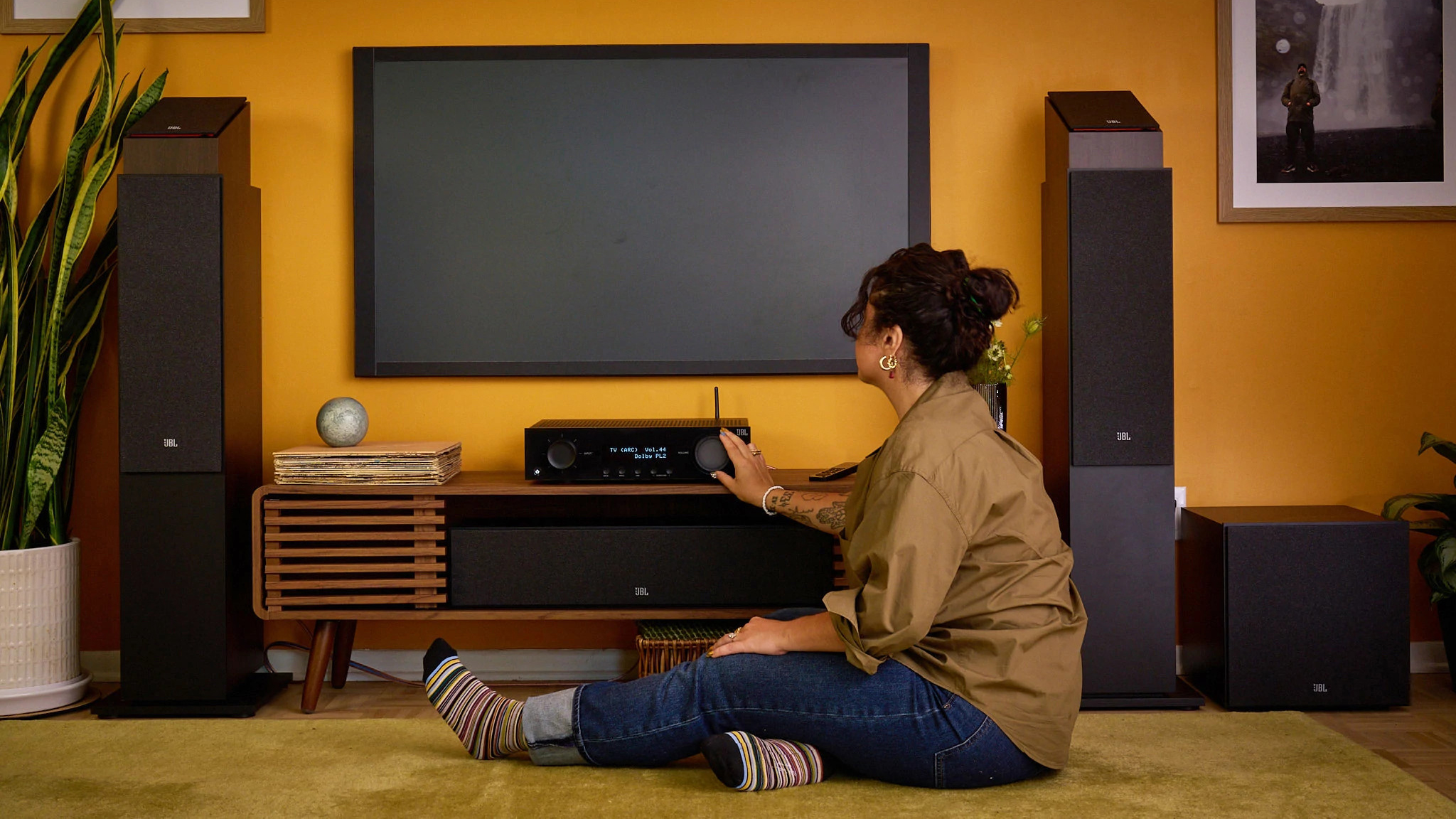 A person using a JBL receiver in a modern living room