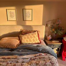 Bedroom with sunlight hitting pillows, headboard and wall