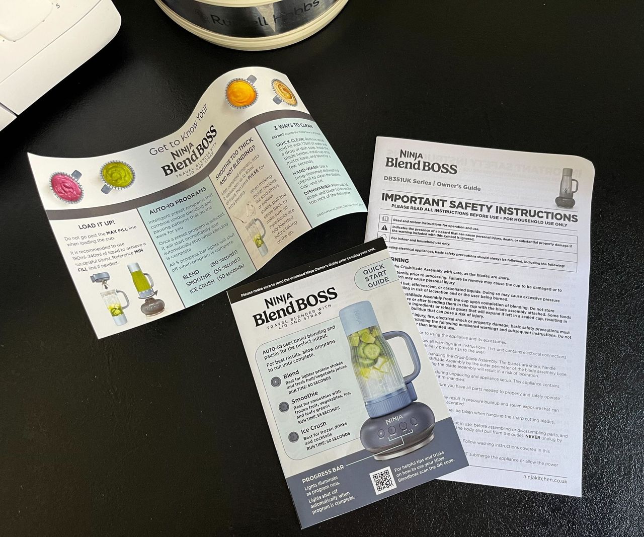 The three information booklets that come with a Ninja Blendboss on a black counter.