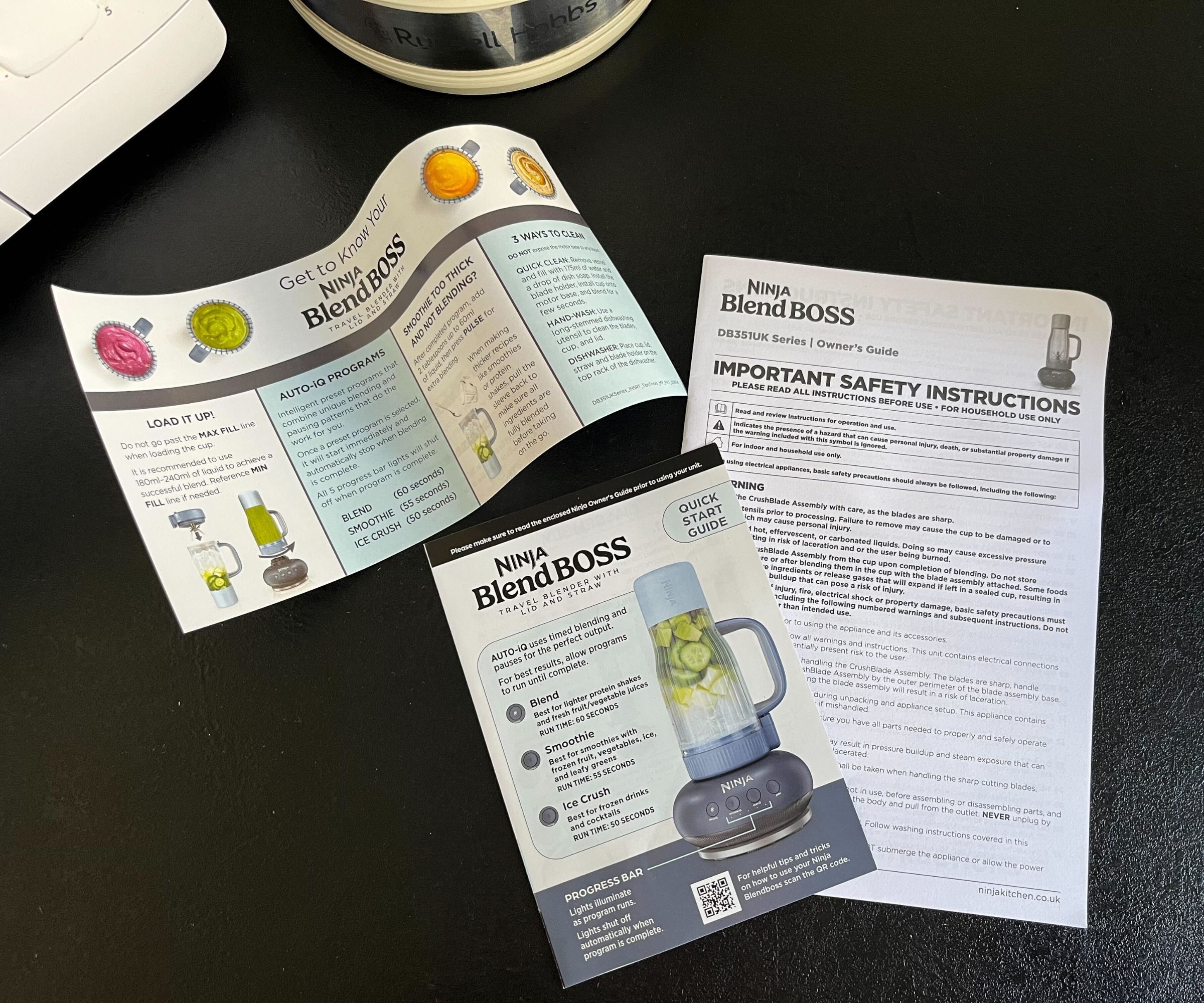 The three information booklets that come with a Ninja Blendboss on a black counter. 