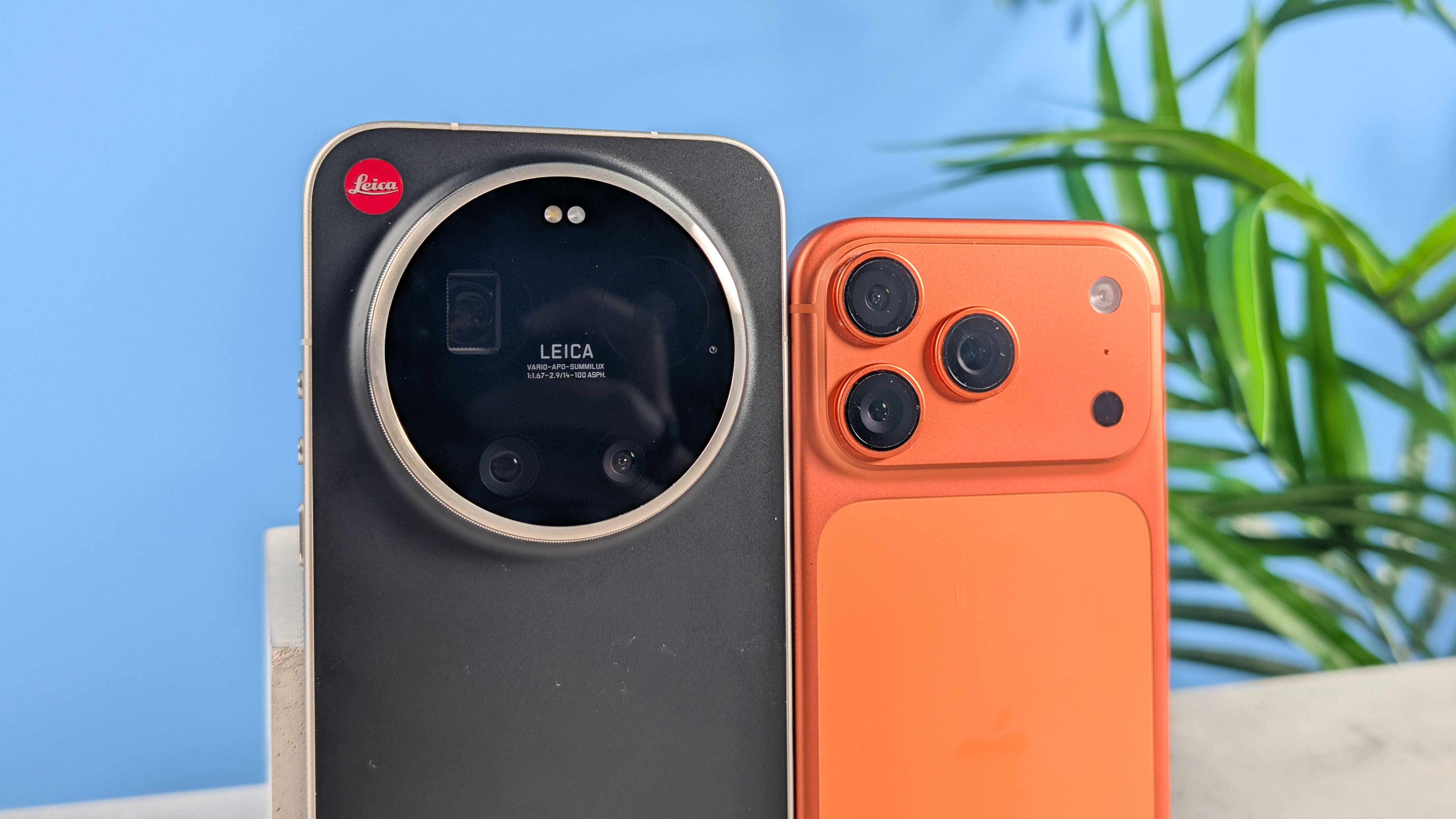 A black Leica Leitzphone and an orange iPhone 17 Pro