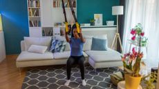 woman using suspension trainer at home