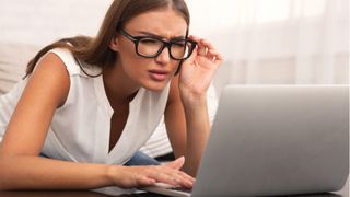 Woman squinting at laptop