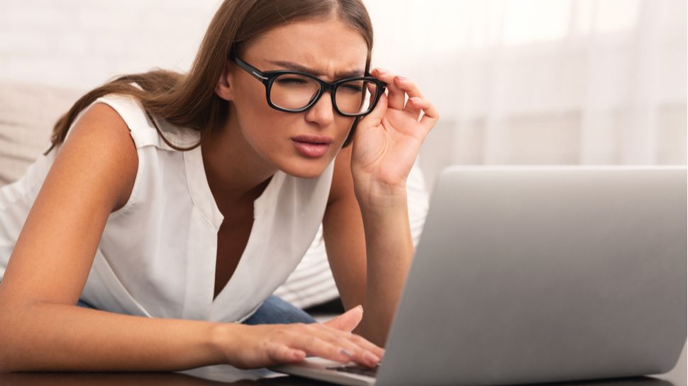 Woman squinting at laptop