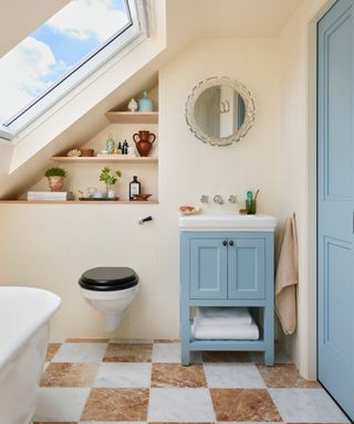 toilet, vanity unit and sink in bathroom with sloped ceiling and skylights